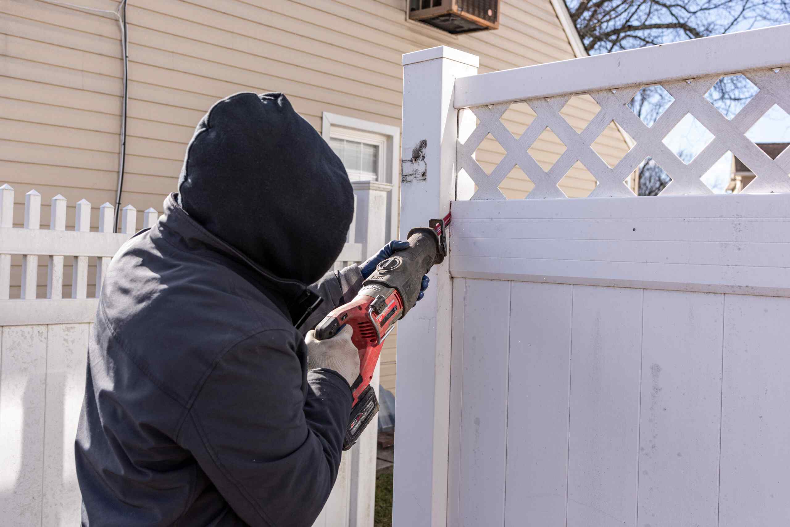 Fence Pro installer cutting a vinyl panel to fit during a repair in New Jersey