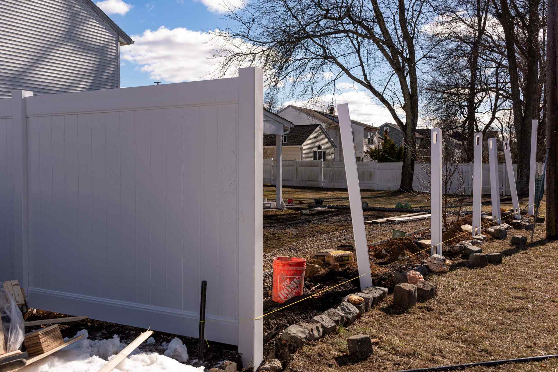 Vinyl fence posts being reset and re-squared during a repair job